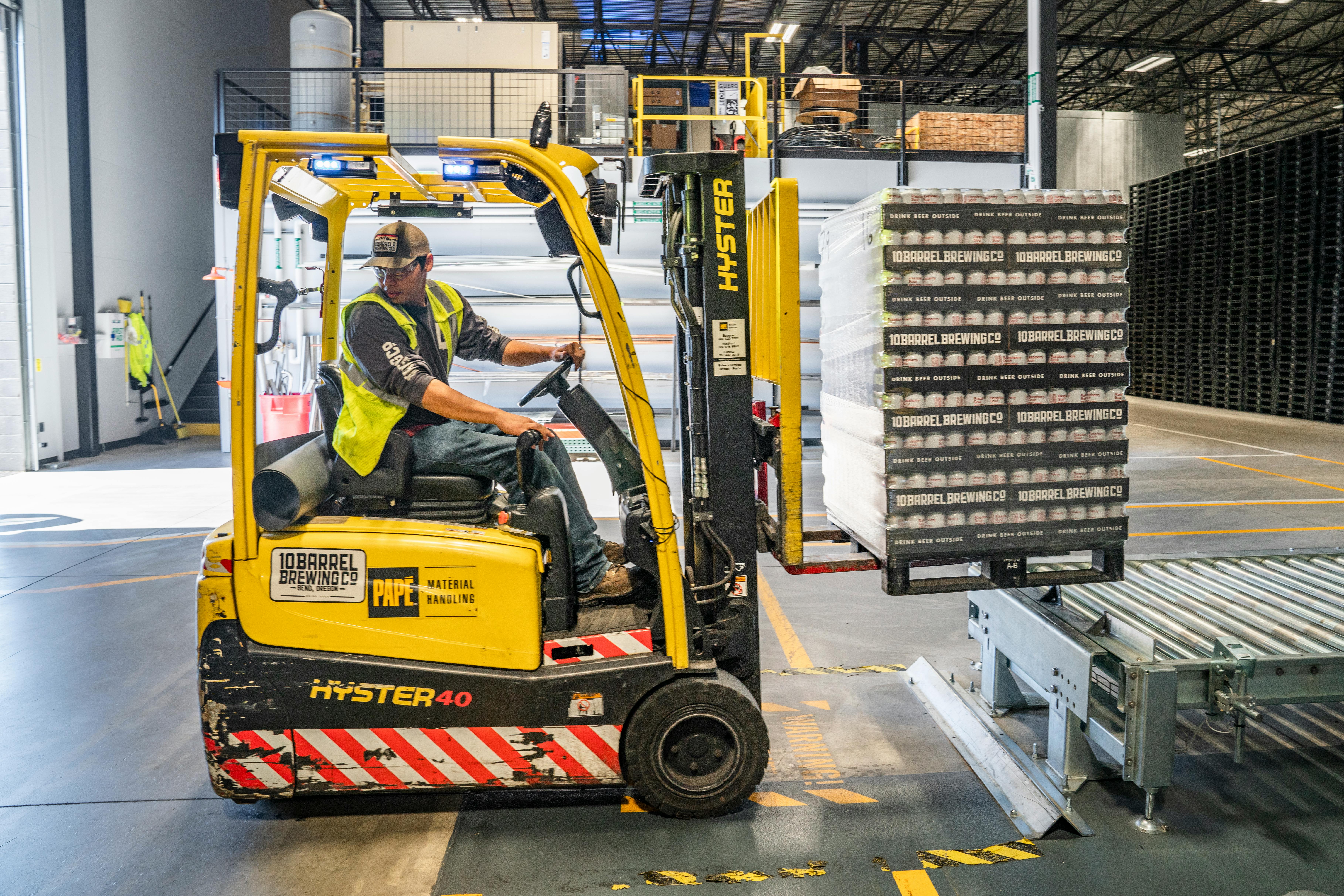 warehouse worker moves pallets