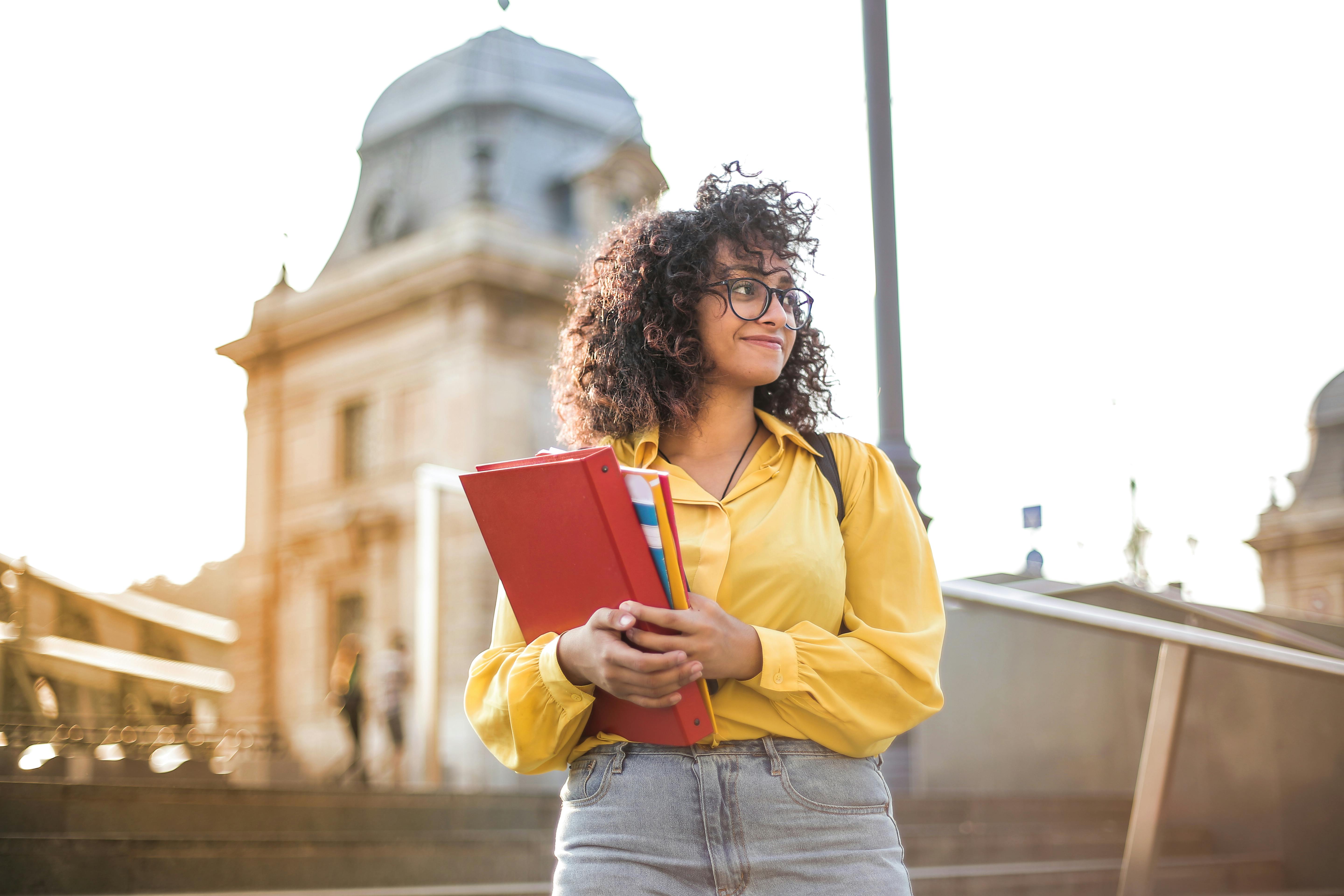 female student carries books on campus